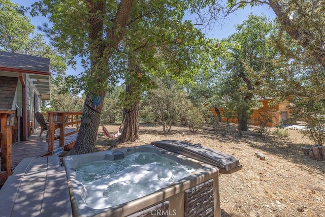 view of yard featuring an outdoor hot tub and a wooden deck