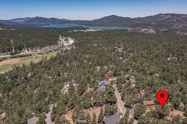 aerial view with a wooded view and a water and mountain view