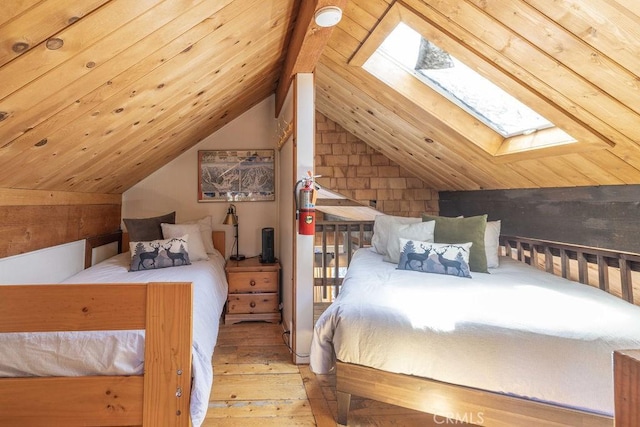 bedroom with lofted ceiling with skylight, wood ceiling, and hardwood / wood-style floors