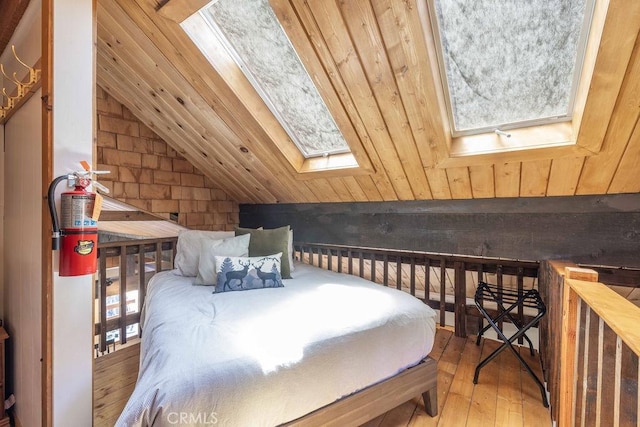 bedroom featuring lofted ceiling with skylight and wood-type flooring