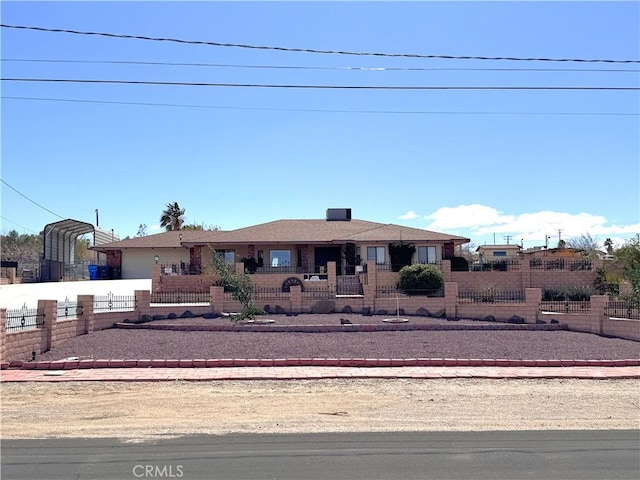 ranch-style house with a fenced front yard and a carport