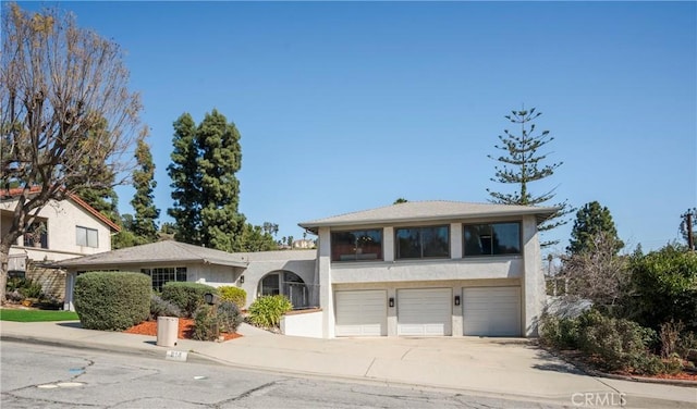 view of front of home featuring concrete driveway, an attached garage, and stucco siding