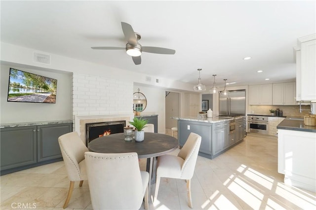 dining space featuring visible vents, recessed lighting, a fireplace, and a ceiling fan