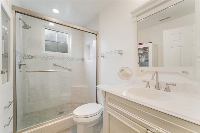 full bathroom featuring vanity, a shower stall, toilet, and visible vents