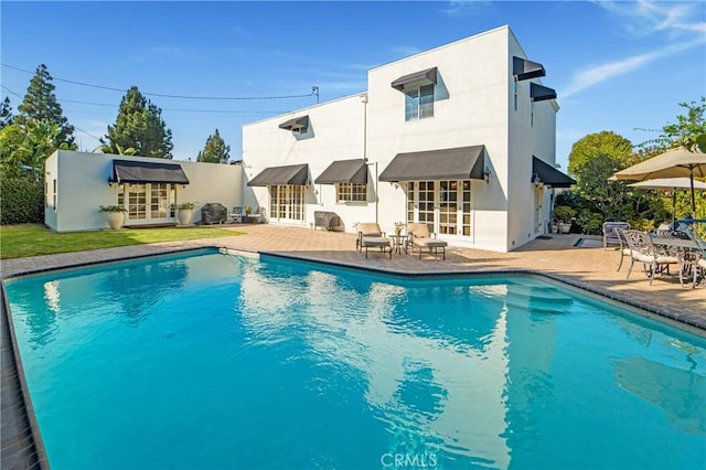 outdoor pool featuring french doors and a patio