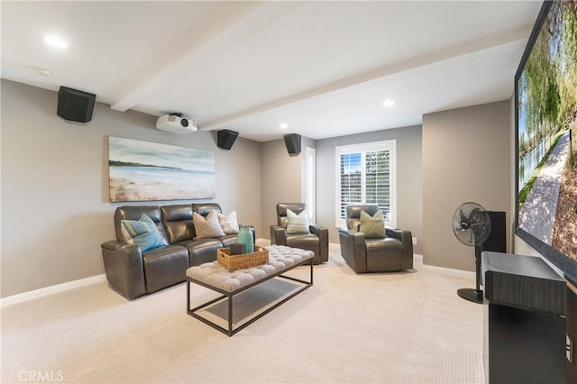 living area with beam ceiling, light colored carpet, and baseboards