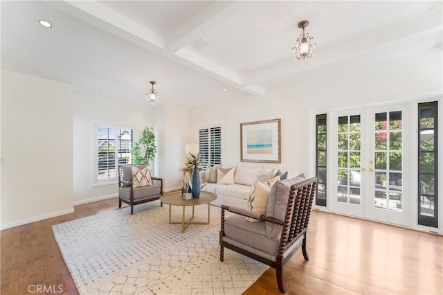 living area featuring beamed ceiling, wood finished floors, recessed lighting, baseboards, and a chandelier