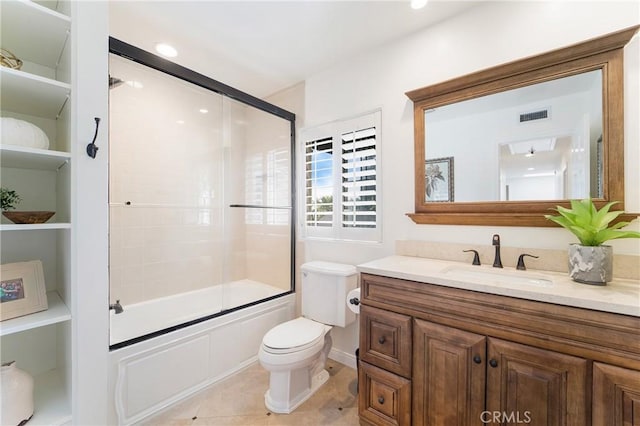 full bathroom featuring visible vents, bath / shower combo with glass door, toilet, tile patterned floors, and vanity