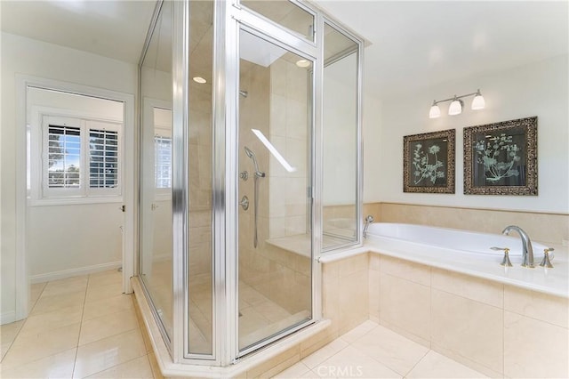 bathroom with tile patterned floors, baseboards, a garden tub, and a shower stall