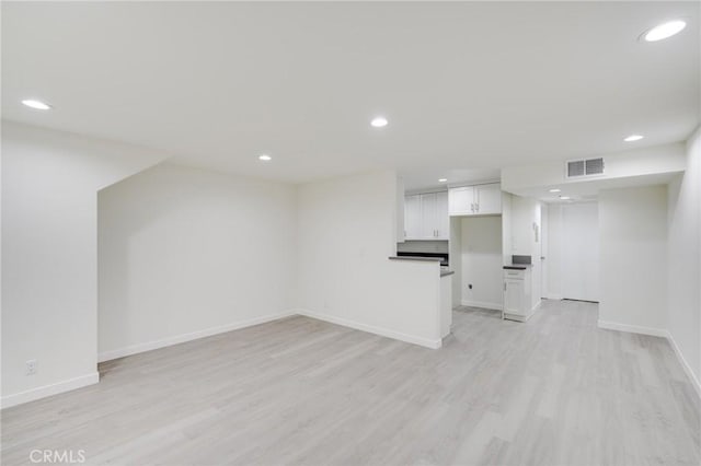 unfurnished living room with baseboards, light wood-style flooring, visible vents, and recessed lighting