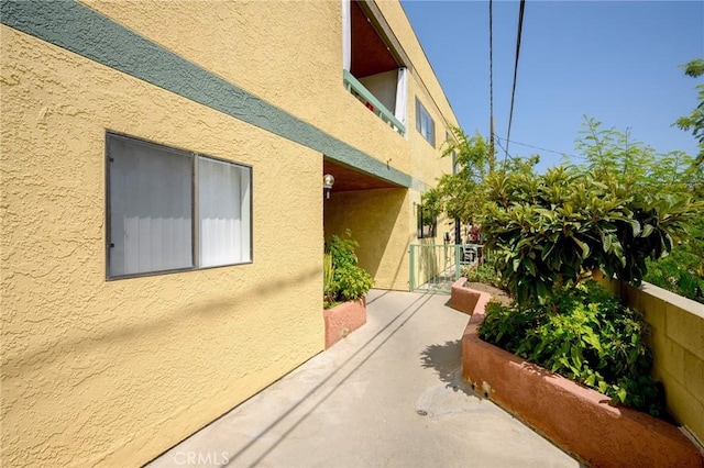 view of side of home with fence and stucco siding