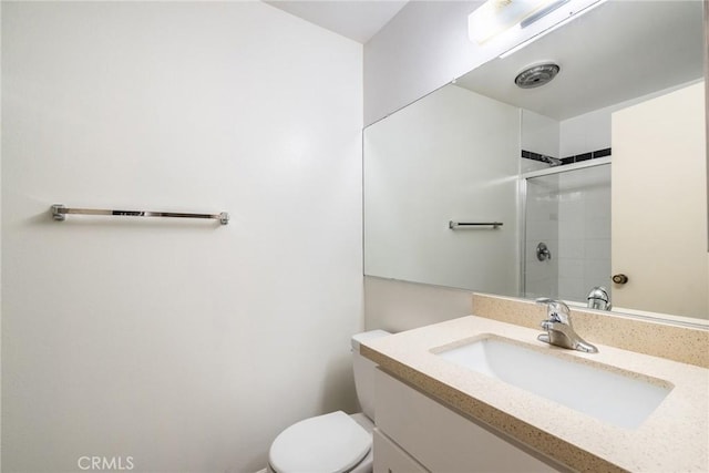 full bath featuring a stall shower, vanity, and toilet