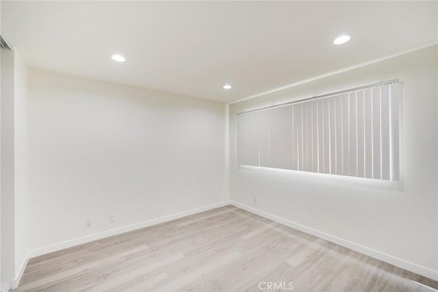 unfurnished room featuring recessed lighting, light wood-style flooring, and baseboards