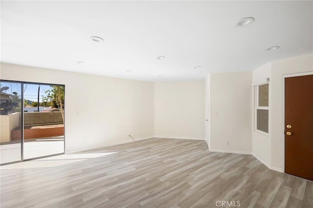 unfurnished room featuring light wood-style flooring, baseboards, and recessed lighting