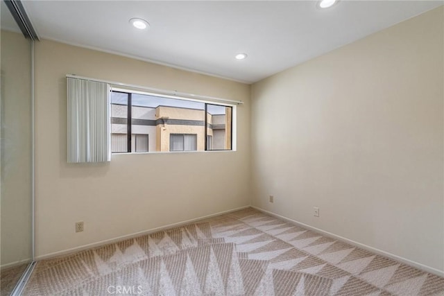 spare room with carpet floors, recessed lighting, and baseboards