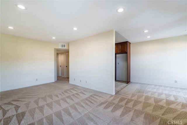 unfurnished room with light colored carpet, visible vents, and recessed lighting