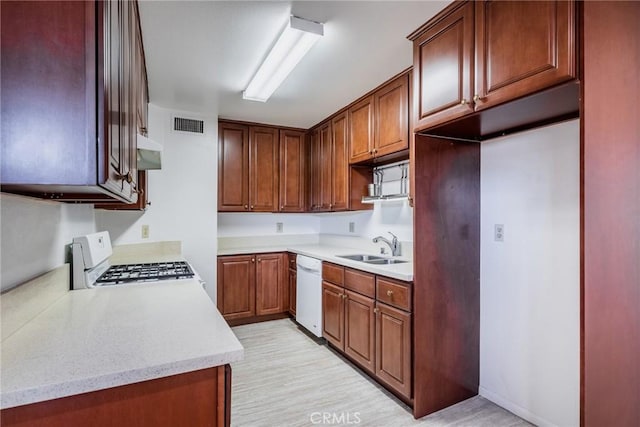 kitchen with white appliances, visible vents, extractor fan, and a sink