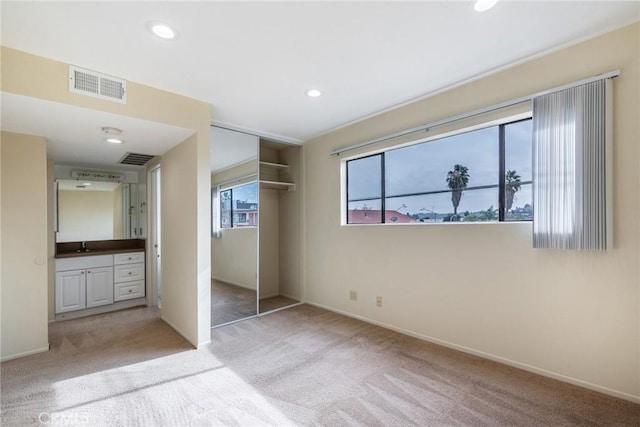 unfurnished bedroom with carpet floors, visible vents, a closet, and recessed lighting