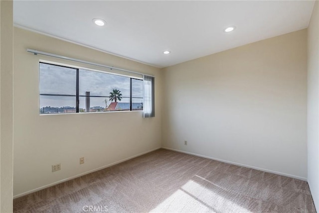 carpeted empty room with baseboards and recessed lighting