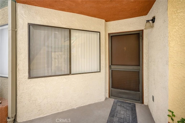 entrance to property with stucco siding