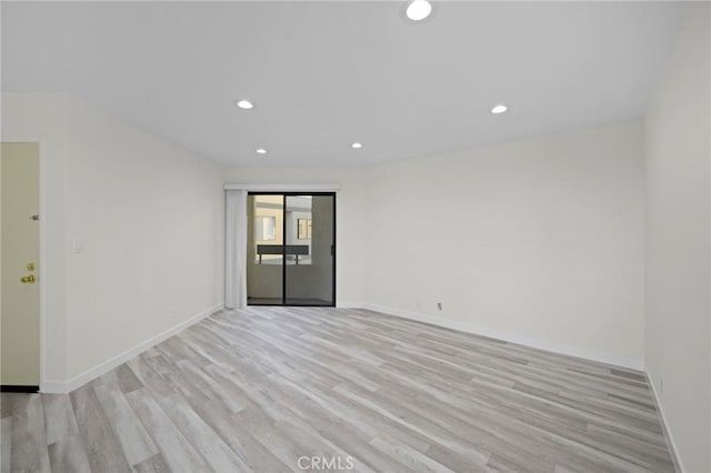 unfurnished room with light wood-type flooring, baseboards, and recessed lighting