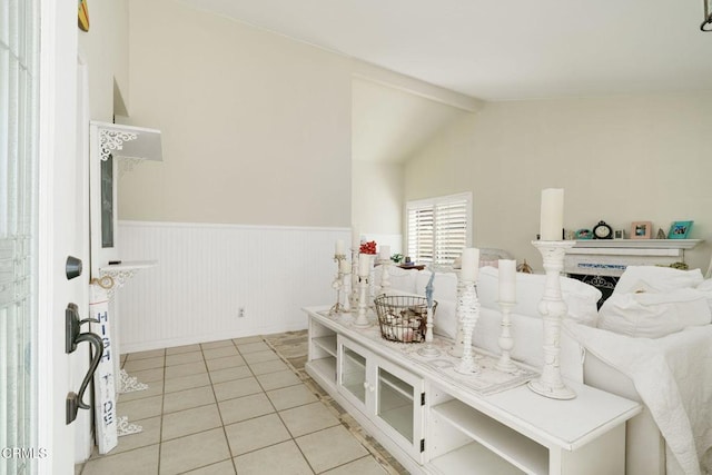 mudroom featuring wainscoting, vaulted ceiling with beams, and light tile patterned floors