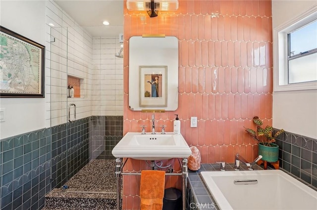 bathroom featuring a garden tub, a sink, tile walls, and a shower stall