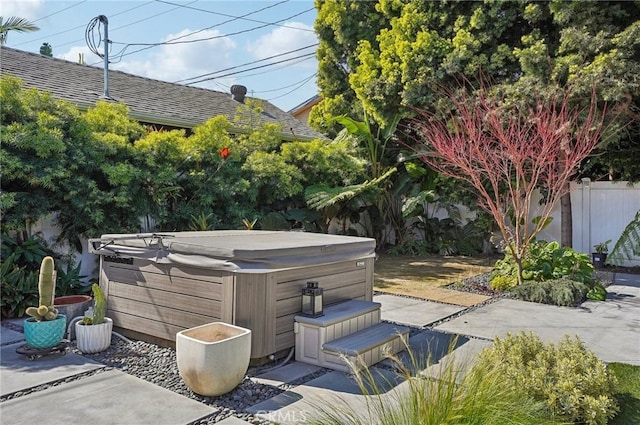 view of patio featuring a hot tub and fence