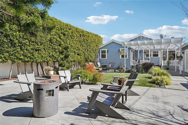 view of patio / terrace with fence, a fire pit, and a pergola