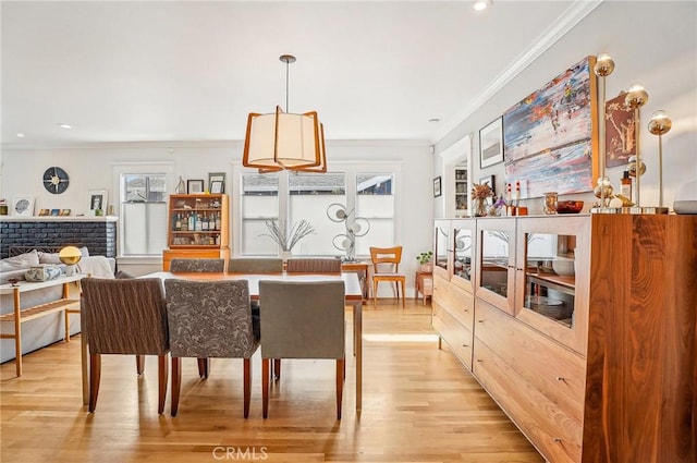 dining space with light wood finished floors, crown molding, and recessed lighting