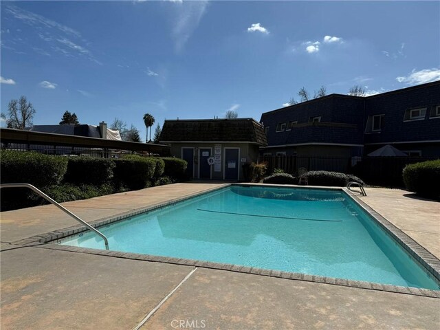 community pool featuring a patio and fence