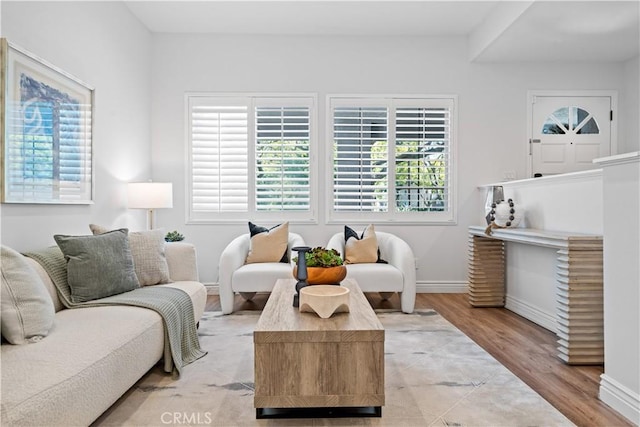 living area with light wood-type flooring and baseboards