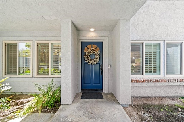 property entrance with stucco siding