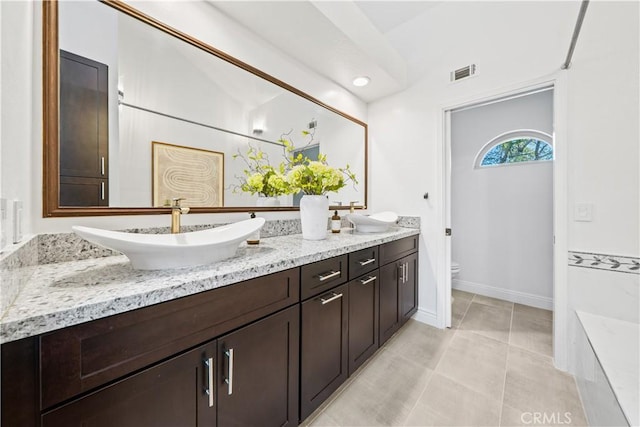 bathroom with double vanity, visible vents, toilet, vaulted ceiling, and a sink