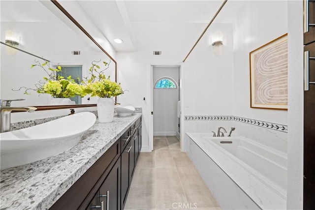 bathroom with a garden tub, a sink, visible vents, and double vanity