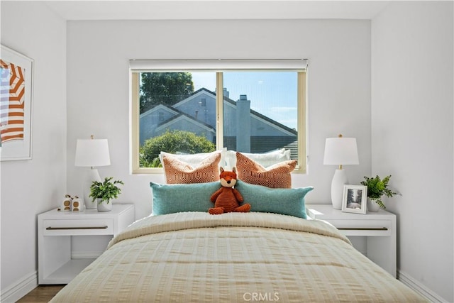 bedroom with baseboards and wood finished floors