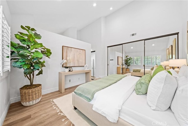 bedroom featuring high vaulted ceiling, recessed lighting, wood finished floors, visible vents, and baseboards