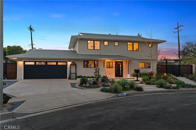 view of front facade with a garage, concrete driveway, fence, and stucco siding