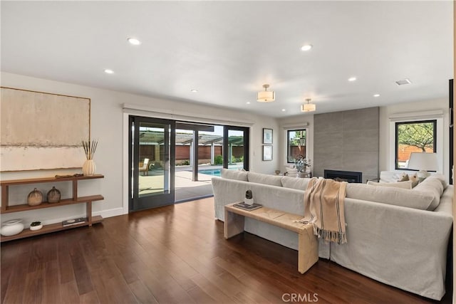 living area with a fireplace, baseboards, dark wood-style flooring, and recessed lighting