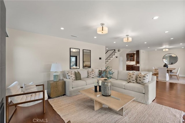 living room featuring stairs, recessed lighting, visible vents, and wood finished floors