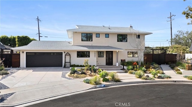 view of front of home featuring a garage, fence, driveway, and stucco siding