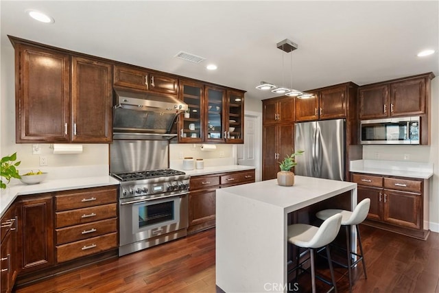 2885 Europa Dr, Costa Mesa, CA 92626 - kitchen featuring visible vents, under cabinet range hood, appliances with stainless steel finishes, light countertops, and dark wood-style flooring