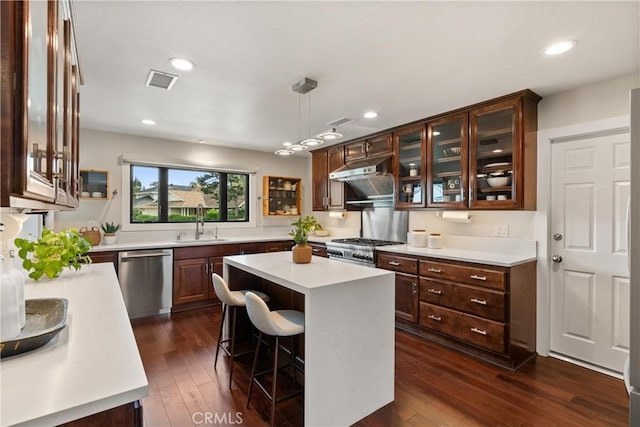 kitchen with dark wood finished floors, light countertops, visible vents, stove, and dishwasher