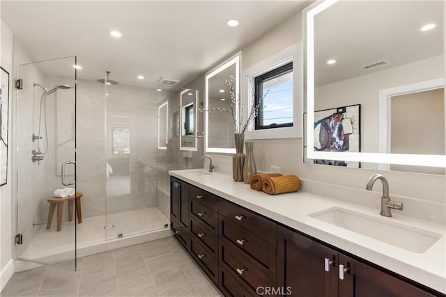 bathroom with recessed lighting, visible vents, a sink, and a shower stall