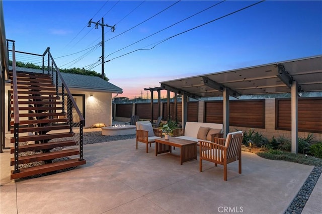 view of patio / terrace featuring an outdoor living space with a fire pit, fence, and stairs