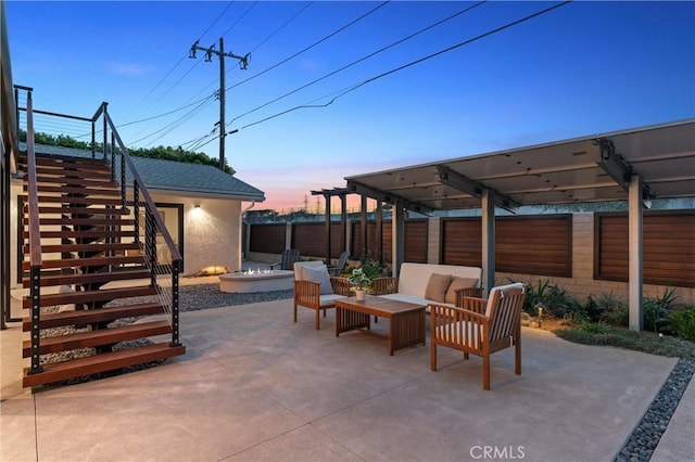 2885 Europa Dr, Costa Mesa, CA 92626 - patio terrace at dusk featuring an outdoor living space with a fire pit, stairs, and fence