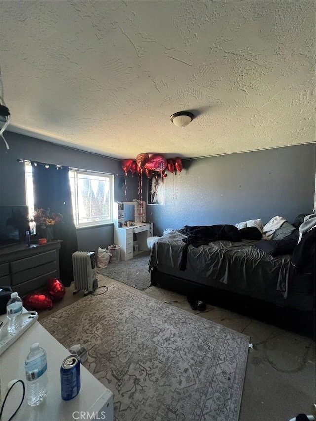 bedroom featuring a textured ceiling and radiator heating unit