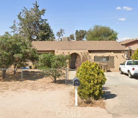 ranch-style house featuring a fenced front yard and stucco siding