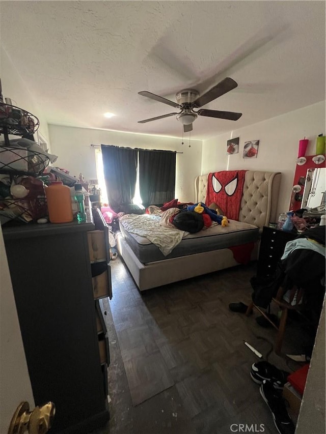 bedroom featuring a ceiling fan and a textured ceiling