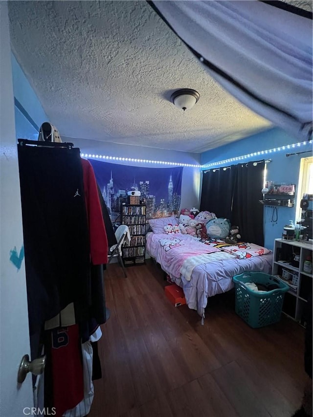 bedroom with a textured ceiling and wood finished floors